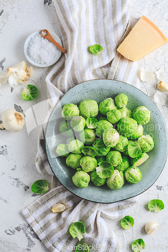 Image of Raw Brussel sprouts with salt and Parmesan cheese in bowl