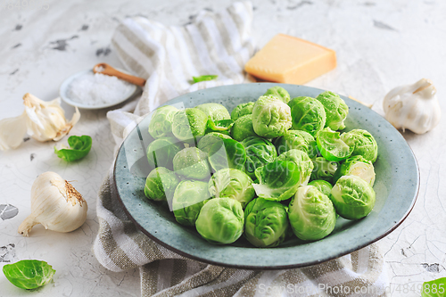 Image of Raw Brussel sprouts with salt and Parmesan cheese in bowl