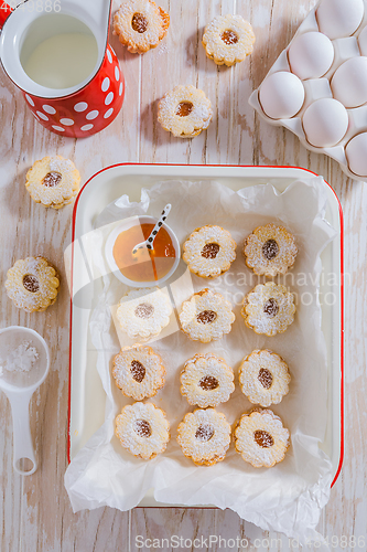 Image of Homemade Christmas cookies with baking ingredients in white