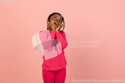 Image of Handsome african little girl portrait isolated on pink studio background with copyspace