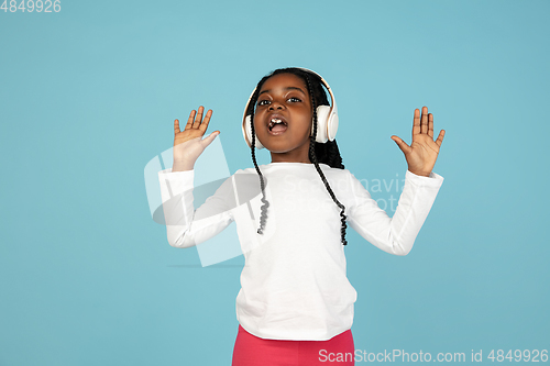 Image of Handsome african little girl portrait isolated on blue studio background with copyspace