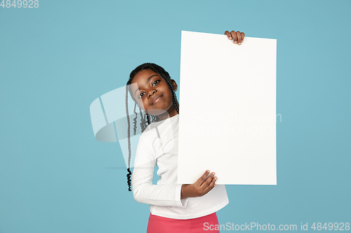 Image of Handsome african little girl portrait isolated on blue studio background with copyspace