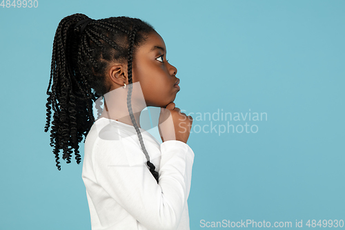 Image of Handsome african little girl portrait isolated on blue studio background with copyspace