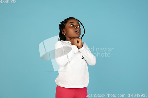 Image of Handsome african little girl portrait isolated on blue studio background with copyspace