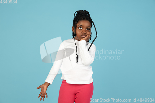 Image of Handsome african little girl portrait isolated on blue studio background with copyspace