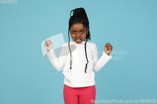 Image of Handsome african little girl portrait isolated on blue studio background with copyspace