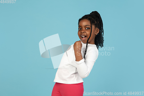 Image of Handsome african little girl portrait isolated on blue studio background with copyspace