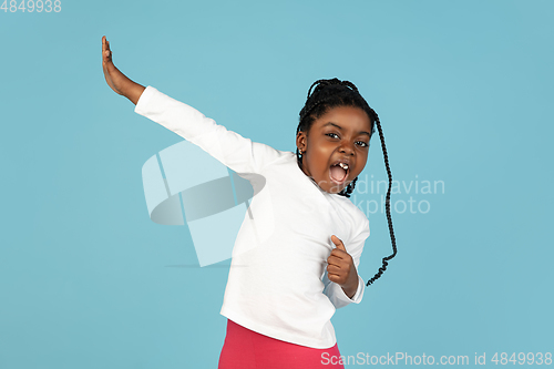 Image of Handsome african little girl portrait isolated on blue studio background with copyspace