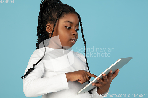 Image of Handsome african little girl portrait isolated on blue studio background with copyspace