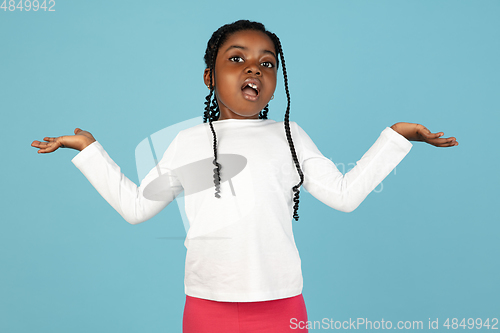 Image of Handsome african little girl portrait isolated on blue studio background with copyspace