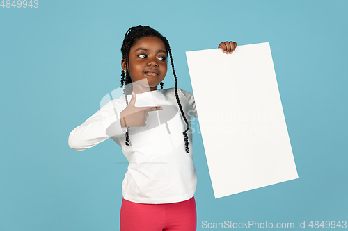 Image of Handsome african little girl portrait isolated on blue studio background with copyspace