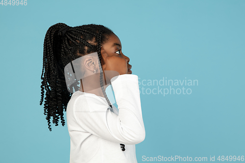 Image of Handsome african little girl portrait isolated on blue studio background with copyspace