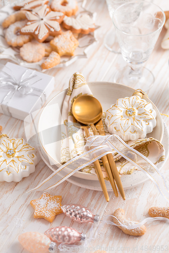 Image of Place setting and Christmas table decorated with ornaments, ging