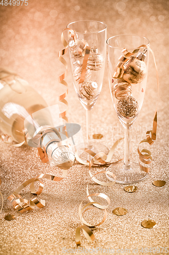 Image of New years eve celebration background with champagne, glasses and ornaments