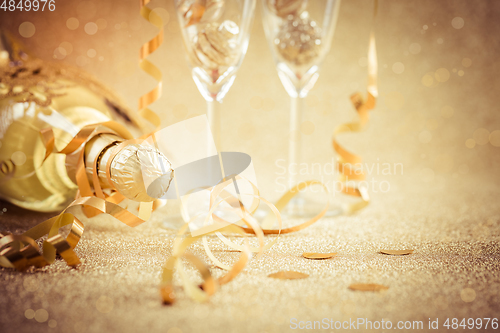 Image of New years eve celebration background with champagne, glasses and ornaments