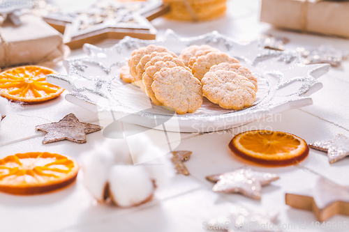 Image of Christmas cookies with orange slices, ornaments on white background