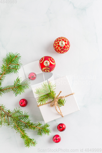 Image of Christmas composition. Christmas gift, fir branches on wooden white background. Flat lay, top view, copyspace