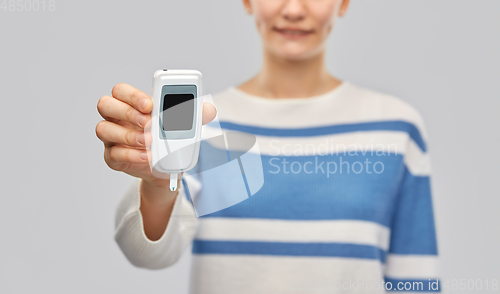 Image of happy smiling teenage girl with glucometer