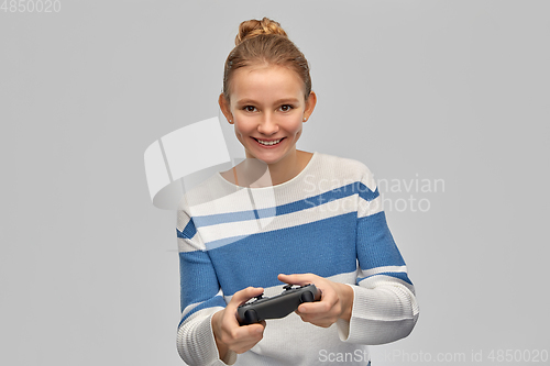 Image of happy teenage girl with gamepad playing video game