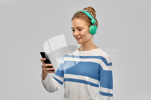 Image of smiling teenage girl in headphones with smartphone