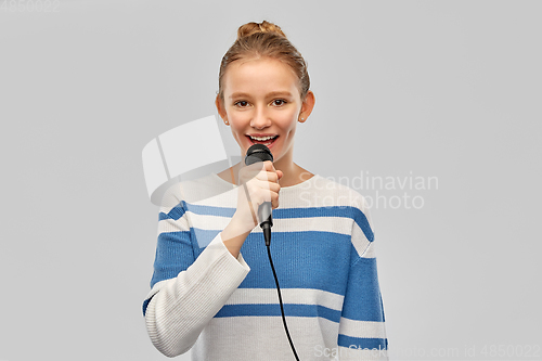 Image of smiling teenage girl with microphone singing