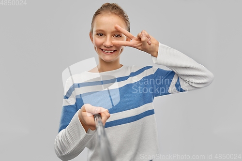 Image of happy teenage gir taking selfie and showing peace