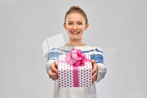 Image of smiling teenage girl in pullover with gift box