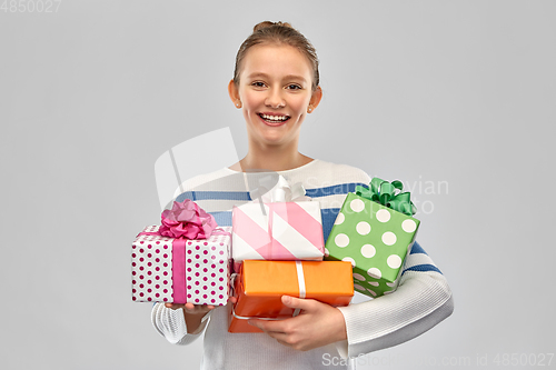 Image of smiling teenage girl in pullover with gift box