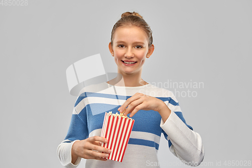 Image of smiling teenage girl eating popcorn