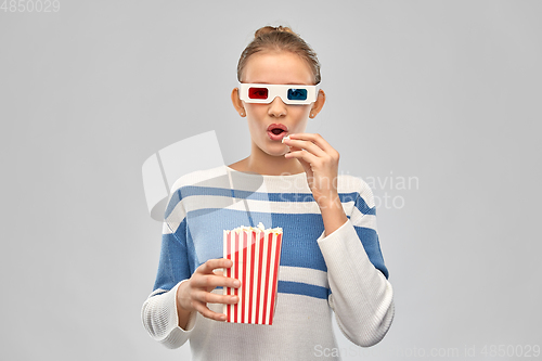 Image of teenage girl in 3d movie glasses eating popcorn