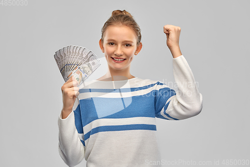Image of smiling teenage girl with dollar money banknotes