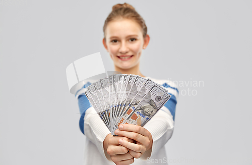 Image of smiling teenage girl with dollar money banknotes