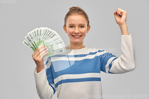 Image of smiling teenage girl with euro money banknotes