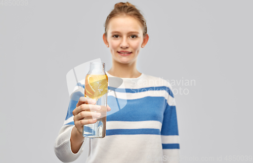 Image of teenage girl with glass bottle of fruit water