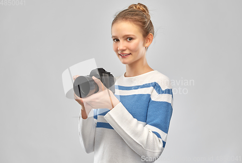 Image of smiling teenage girl r with digital camera