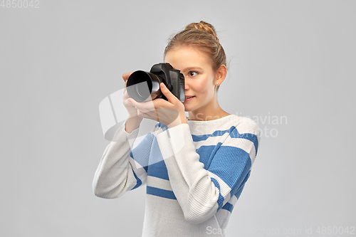 Image of smiling teenage girl r with digital camera