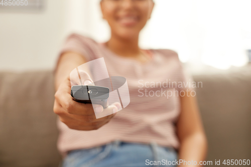 Image of happy african american woman watching tv at home