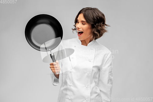 Image of smiling female chef in toque with frying pan