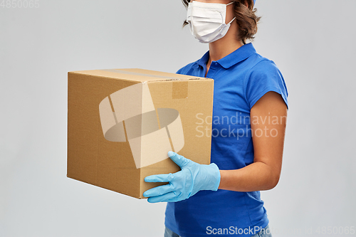 Image of delivery woman in face mask holding parcel box