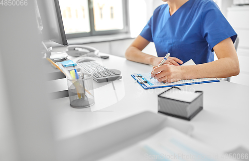 Image of doctor or nurse with clipboard at hospital