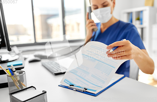 Image of doctor with computer calling on phone at hospital