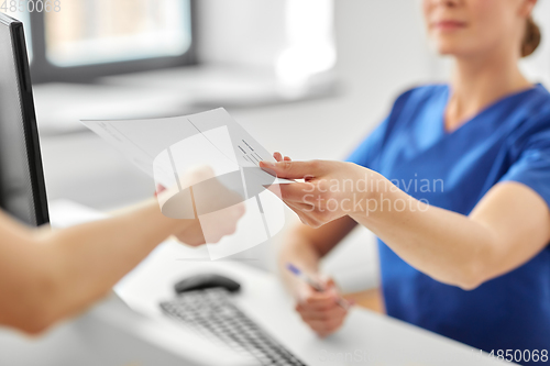 Image of doctor and patient with prescription at hospital