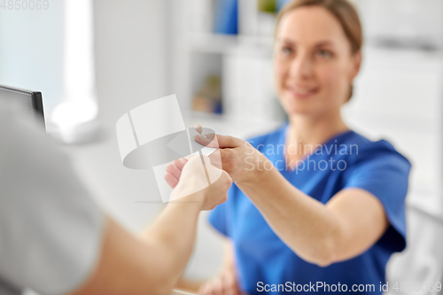 Image of patient giving tag to doctor or nurse at hospital