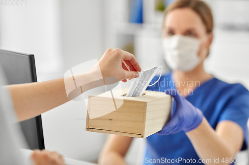 Image of doctor offering mask to patient at hospital