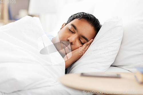 Image of indian man sleeping in bed at home