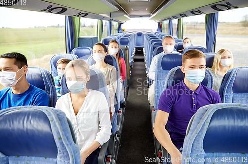 Image of group of passengers in medical masks in travel bus