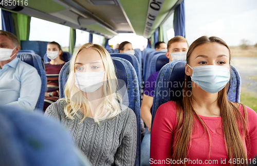 Image of young women passengers in masks in travel bus