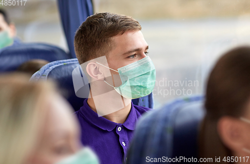 Image of young man in medical mask sitting in travel bus