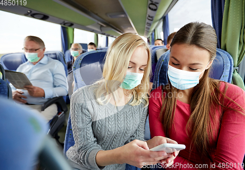 Image of happy young women in travel bus with smartphone