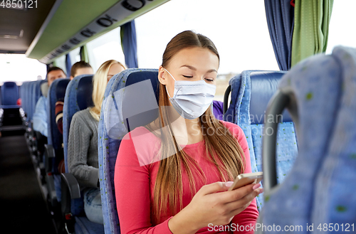 Image of woman in mask with smartphone in travel bus